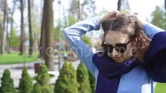 戴太阳镜的漂亮年轻女人摆姿势视频的预览图