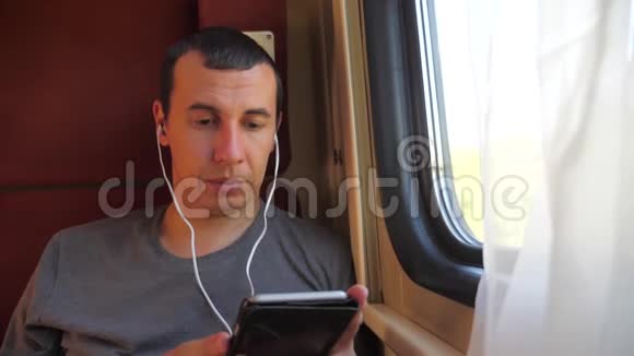 男子听着火车车厢车厢车厢车厢上的音乐旅行慢动作视频有生活方式的男人视频的预览图