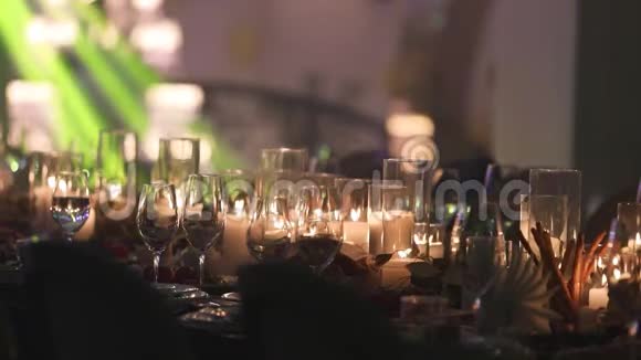 餐桌上的装饰蜡烛桌子上的眼镜和圣诞蜡烛带玻璃的白色蜡烛视频的预览图