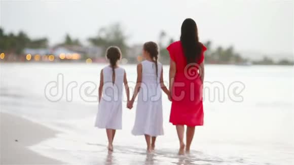 可爱的小女孩和年轻的妈妈在白沙滩玩视频的预览图