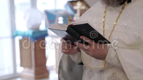 神父在教堂用圣经书祈祷视频的预览图