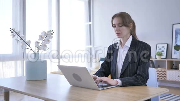 年轻女性在工作在办公室的笔记本电脑上打字视频的预览图