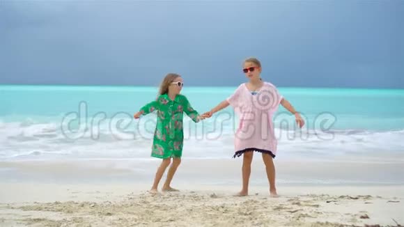 可爱的小女孩一起在热带海滩玩耍视频的预览图