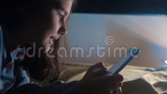 少女和智能手机小青少年帽女孩在社交媒体生活方式信使之夜的聊天留言视频的预览图