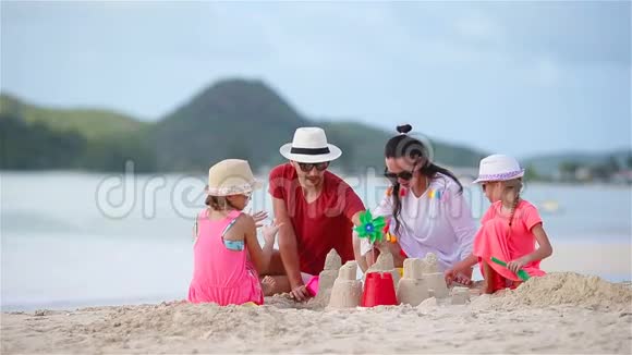 一家人在热带白海滩制作沙堡视频的预览图