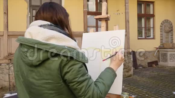 年轻的艺术家在城里画画艺术家们在街上画画学生画旧欧洲的建筑视频的预览图