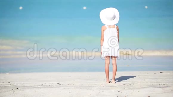 加勒比海度假海滩上穿白色衣服的小可爱女孩视频的预览图