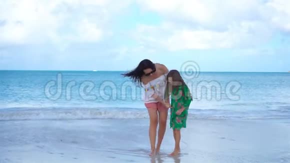 加勒比海海滩上美丽的母亲和小女儿一起玩耍视频的预览图
