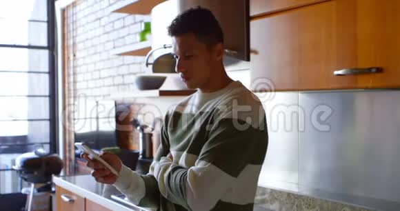 男人在厨房用手机视频的预览图