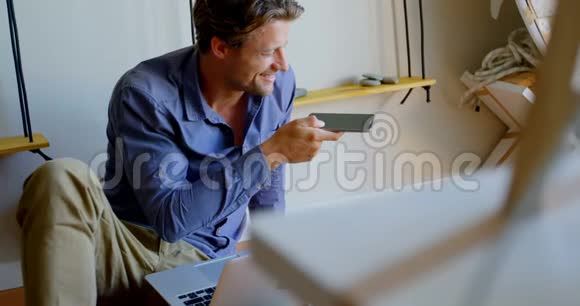 男人在家里用手机说话视频的预览图