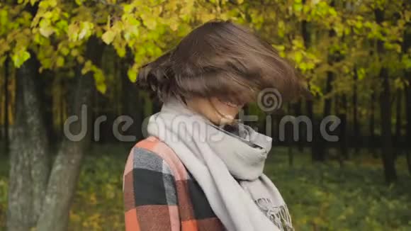 秋天的女孩在城市公园散步秋天的森林里快乐可爱美丽的年轻女子的肖像视频的预览图