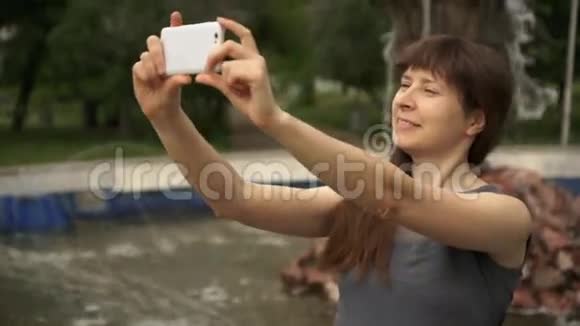 女人拿着电话坐在喷泉旁视频的预览图