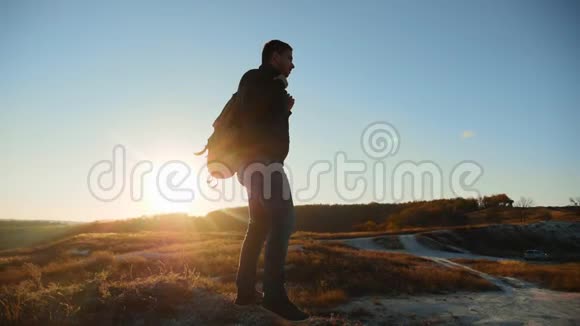 男子剪影漫步旅游徒步探险登山者日落爬山慢动作视频徒步旅行者的阳光视频的预览图