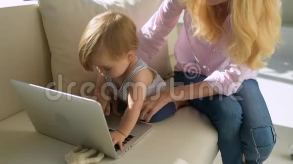 带着孩子在笔记本电脑上的积极的母亲视频的预览图