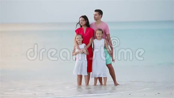 四个幸福的家庭在白色海滩玩得开心视频的预览图