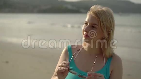 海滩上的年轻女子戴着太阳镜视频的预览图