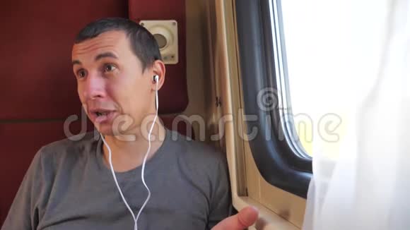 男人听着火车上的音乐生活方式火车车厢车厢旅行慢动作视频一个男人视频的预览图