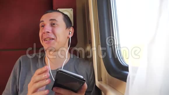 男子听着火车车厢上的音乐乘坐跑车生活方式车厢旅行慢动作视频一个男人视频的预览图