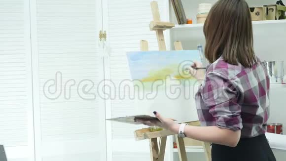 艺术家用调色板在手中画一幅油画视频的预览图