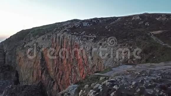 日落时带灯塔和悬崖的南斯塔克的鸟瞰图视频的预览图