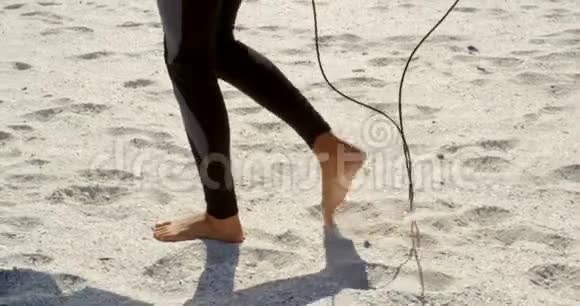 在海滩上拿着冲浪板走路的女人视频的预览图