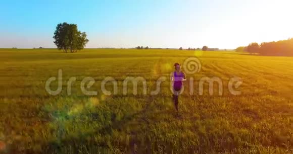 低空无人驾驶飞机在完美沥青路上的运动女子面前飞行视频的预览图
