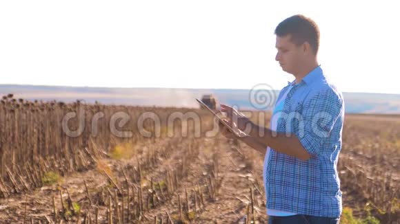 农民聪明的农业工作生活方式男人阅读或分析收获向日葵在平板电脑上的农业报告视频的预览图