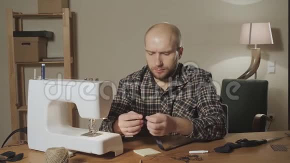 漂亮的年轻人做裁缝在纺织工作室里使用缝纫机领结视频的预览图