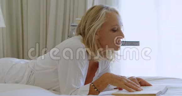 在卧室4k的床上看书的女人视频的预览图