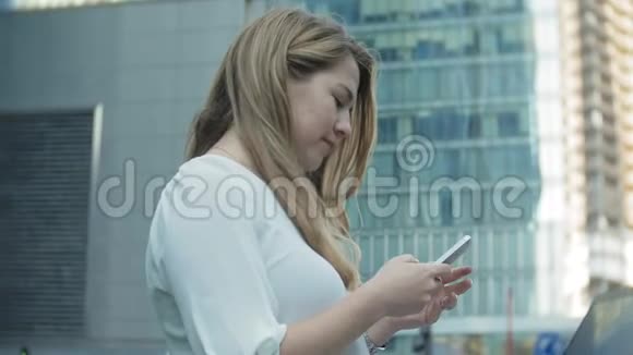 年轻女商人在城市公园商务中心使用智能手机视频的预览图