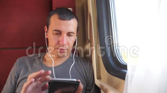 男子听音乐在火车上旅行火车车厢车厢旅行慢动作视频一个男人视频的预览图