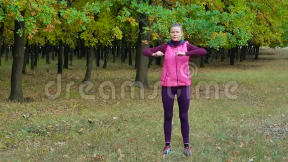 美丽的健身运动女孩在秋季公园跑步前热身户外健身视频的预览图