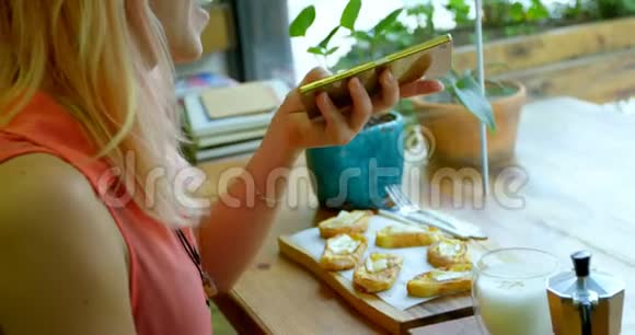 年轻女子坐在咖啡馆里打电话视频的预览图