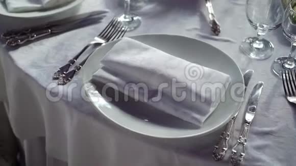 餐厅餐桌上白布上的餐盘餐巾纸刀叉视频的预览图