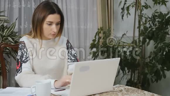 年轻漂亮的女性在家打手提电脑视频的预览图