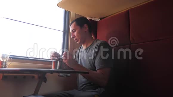 男人坐在火车车厢里手里拿着咖啡和茶慢动作视频男人在喝茶视频的预览图