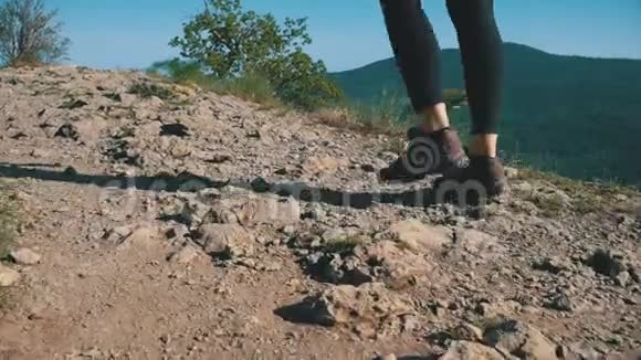 漫步在山顶悬崖峭壁上的旅行妇女徒步旅行在岩石上行走视频的预览图