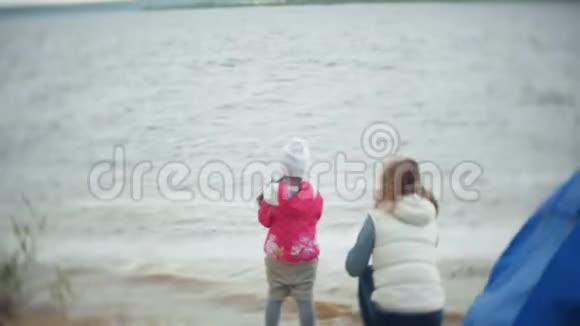 幸福美丽的母女在河岸的沙滩上喂海鸥视频的预览图
