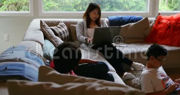 母子俩在客厅用笔记本电脑4k视频的预览图