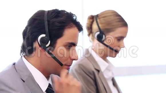 呼叫中心工作人员在耳机上交谈视频的预览图