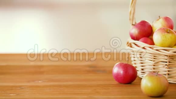 木桌上柳条篮子里的熟苹果视频的预览图