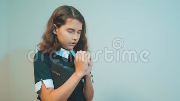 小女孩用手中的圣经祈祷天主教神圣的圣经儿童与宗教视频的预览图