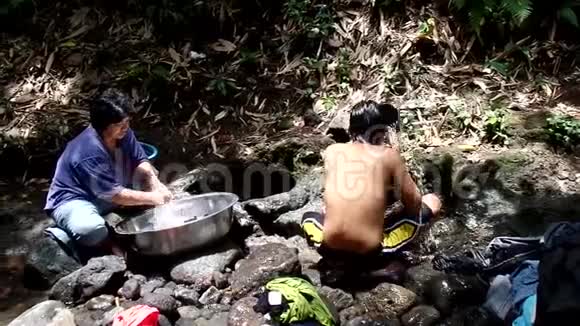 菲律宾农村社区缺乏公共供水系统设施迫使这名妇女即使在污染的河流中也要洗衣服视频的预览图