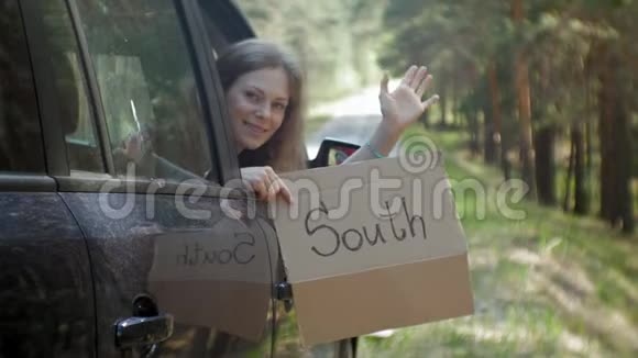 年轻漂亮的女人搭车站在路上背包放在桌上上面写着南方视频的预览图