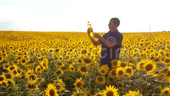 男人的生活方式农民用向日葵探索田野慢动作视频男人的生活方式农民手拿瓶子视频的预览图