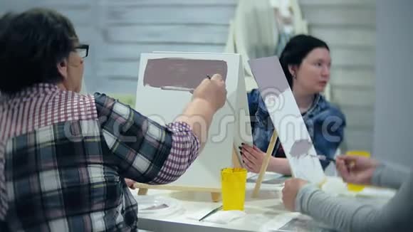艺术学校创造力和人的概念一群学生与画架画刷和调色板绘画静物视频的预览图