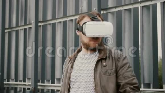 有胡子的帅哥在城市空间里使用虚拟现实眼镜4k视频的预览图