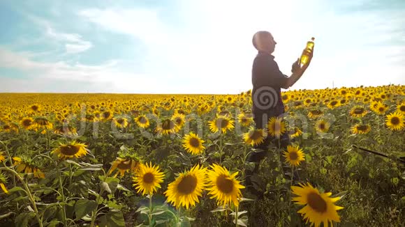 男人的生活方式农民手里拿着一瓶着一瓶葵花油农民农业塑料瓶视频的预览图