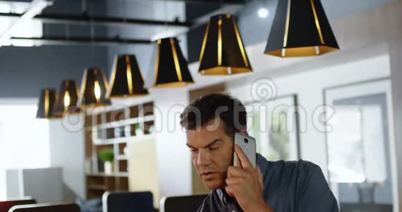 男性高管在办公桌上打手机4k视频的预览图