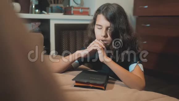 小女孩圣经祈祷与生活方式圣经在她的手中天主教神圣的圣经儿童和视频的预览图
